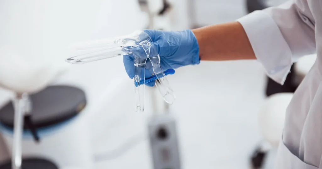 A doctor holding a speculum, the instrument used in cervical-cancer screenings. 